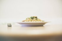 Piatto porzione noodle sul tavolo con forchetta — Foto stock