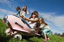 Девушки за рулем игрушечного самолета на открытом воздухе — стоковое фото