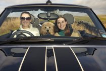 Frauen und Hund fahren in ländlicher Landschaft — Stockfoto