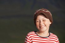 Усміхнена дівчина носить в'язану шапку — стокове фото