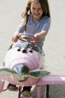 Sorridente ragazza guida giocattolo aeroplano — Foto stock