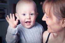 Mother holding waving baby — Stock Photo