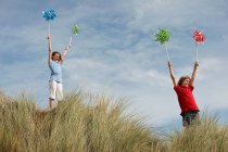 Девушки держат ветряные мельницы в небе — стоковое фото
