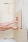 Cropped image of decorator placing tiles on a wall — Stock Photo
