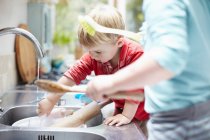 Niños lavando platos juntos - foto de stock