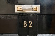 Close up of Newspaper in letterbox with number eighty two — Stock Photo