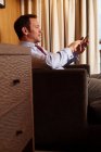 Homme d'affaires sur téléphone portable dans la chambre d'hôtel — Photo de stock
