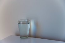 Натюрморт склянки води, розміщеної на столі — стокове фото