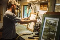 Künstler arbeitet in Werkstatt, rahmt Kunstwerke ein — Stockfoto