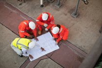 Arbeiter mit Bauplänen in Ölraffinerie — Stockfoto