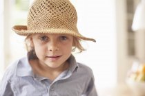 Portrait de garçon portant un chapeau de paille, regardant la caméra — Photo de stock