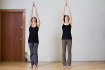 Mujeres estirándose durante el yoga - foto de stock