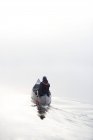 Visão traseira do homem de caiaque na névoa da manhã — Fotografia de Stock