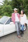 Couple standing beside car — Stock Photo