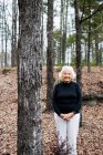 Porträt einer Seniorin im Wald mit gefalteten Händen — Stockfoto