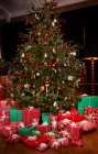 Рождественские подарки под украшенной елкой — стоковое фото