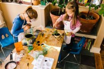 Две девушки проводят научные эксперименты за грязным столом — стоковое фото