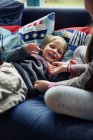 Дети играют вместе на диване — стоковое фото