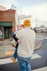 Батько носить молодого сина через пішохідний перехід — стокове фото