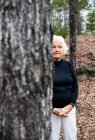 Портрет пожилой женщины в лесу, руки сжаты — стоковое фото
