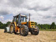 Вождение трактора человек на поле — стоковое фото