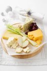 Cheese and fruit on wooden board — Stock Photo