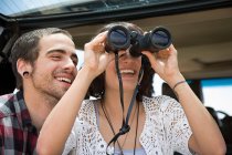 Young couple with binoculars — Stock Photo