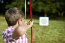 Visão traseira do adolescente praticando tiro com arco — Fotografia de Stock