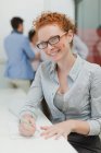 Mujer de negocios tomando notas en la reunión - foto de stock