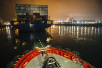 Navire remorqueur manœuvrant un cargo dans le port la nuit, Tacoma, Washington, USA — Photo de stock