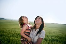 Женщина держит дочь и смотрит на небо — стоковое фото