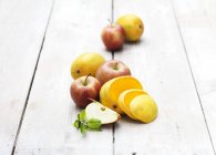 Rodajas de manzana y mango sobre mesa de madera blanqueada - foto de stock