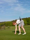 Жінка встановлює гольф трійник на траві — стокове фото