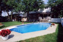 Schwimmbad im Garten mit Häusern im Hintergrund — Stockfoto