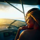 Woman relaxing on man's shoulder on boat at low light — Stock Photo