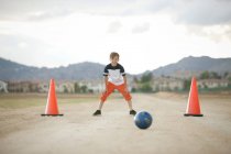 Мальчик в воротах играет в футбол на открытом воздухе — стоковое фото