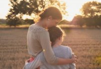 Мати і дочка обіймаються в полі — стокове фото