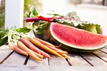 Still life of homegrown watermelon and carrots — Stock Photo