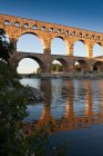 Puente del Gard reflejado en el río - foto de stock