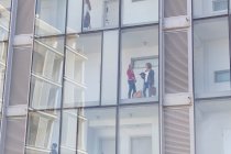 Бізнес-леді розмовляють в коридорі скляного фасаду готелю — стокове фото