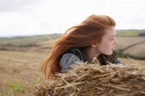 Teenage girl resting on haybale — Stock Photo