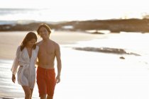 Пара прогулок вместе на пляже, фокус на переднем плане — стоковое фото