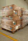 Boîtes en carton sur palettes dans un entrepôt de distribution — Photo de stock
