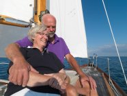 Літня пара розслабляється на вітрильному човні — стокове фото