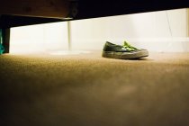 Oberflächenebene Ansicht des Schuhs unter dem Bett — Stockfoto