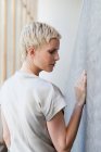 Женщина трогает бетонную стену снаружи — стоковое фото