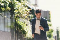 Homem de negócios elegante escolhendo música smartphone, West Village, Manhattan, EUA — Fotografia de Stock