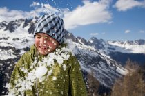 Мальчик, попавший под снежный ком в движении — стоковое фото