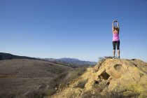 Rear view of woman practicing yoga pose on top of hill, Thousand Oaks, California, USA — Stock Photo