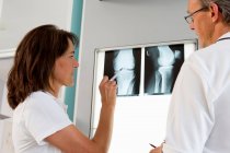 Лікар і медсестра вивчають рентгенівські промені — стокове фото